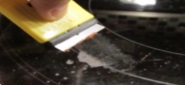 Removing food/residue with a scraper on a ceramic glass cooktops.